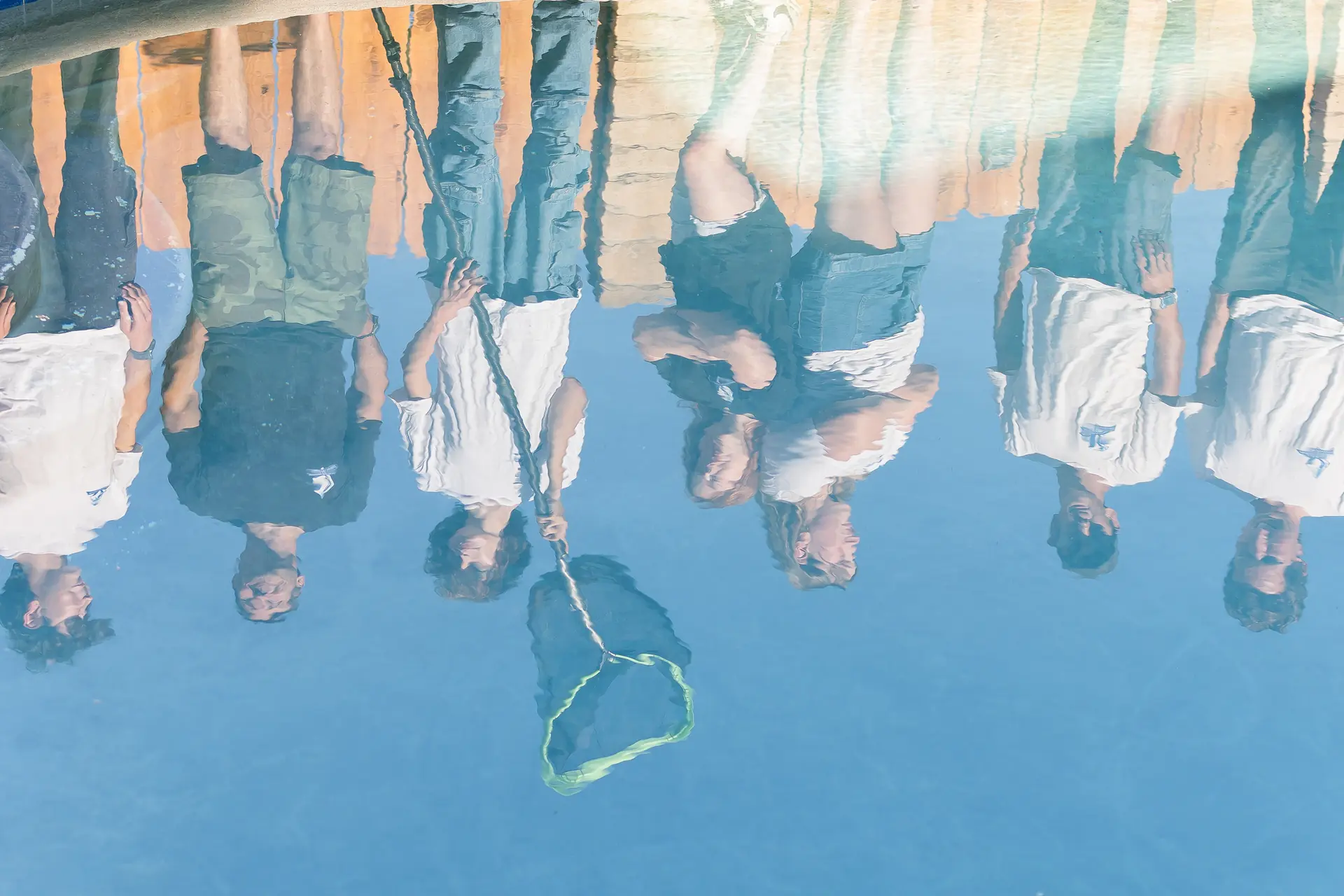 The Murdock Pool Service team reflected in the surface of a freshly serviced San Diego pool